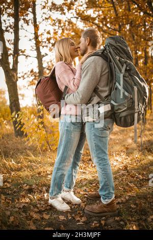 Couple de touristes amoureux dans la forêt d'automne.Un jeune homme et une jeune femme embrasse et embrasse tout en se tenant sur la toile de fond de colo Banque D'Images