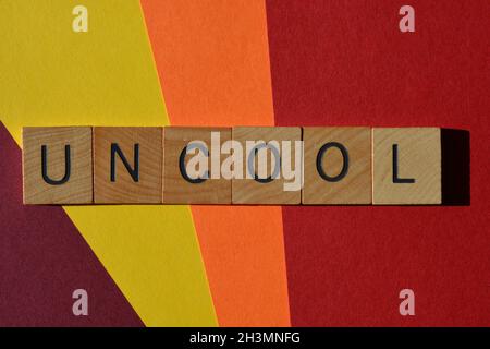 Uncool, mot en lettres de l'alphabet de bois isolées sur fond coloré Banque D'Images