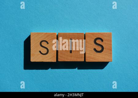 SIS, mot en lettres de l'alphabet en bois isolées sur fond bleu.Une version abrégée de Sister, un salut affectueux pour un ami proche utilisé par G Banque D'Images