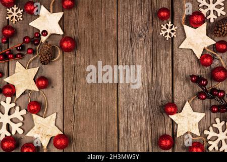Double bordure latérale de Noël avec ornements en bois et boules rouges.Vue de dessus sur un fond de bois rustique. Banque D'Images
