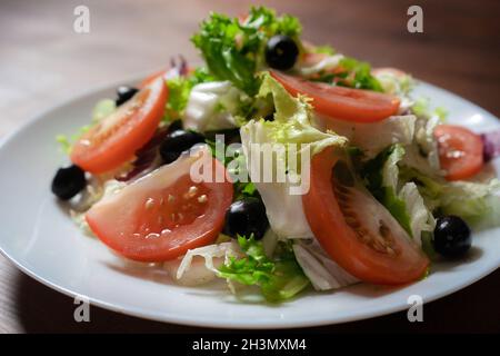 Concept d'alimentation saine.Salade de légumes avec laitue verte, tomates rouges et olives noires.Hors-d'œuvre en vitamines naturelles colorées.FR Banque D'Images