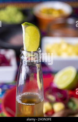 Lime dans une bière avec tortilla mexicaine et salsas Banque D'Images