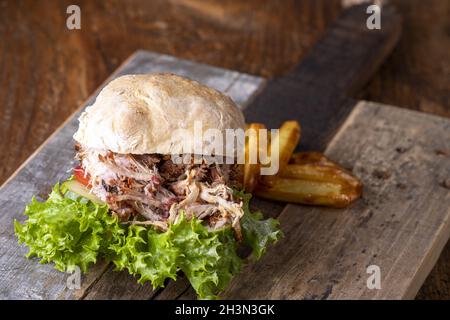 Porc tiré dans un petit pain avec des frites Banque D'Images