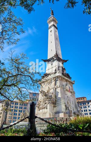 Vue à travers les arbres et contre la barrière des soldats et des marins Monument à Indianapolis, Indiana Banque D'Images