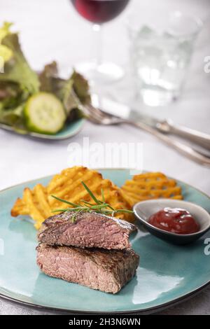 Steak grillé avec grilles de pommes de terre fraîches Banque D'Images