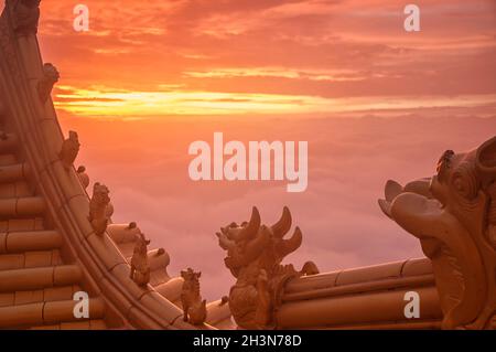 De petites créatures mythiques au sommet de la salle d'or bouddhiste tandis que le soleil se lève sur l'éméishan dans la province du sichuan en chine. Banque D'Images