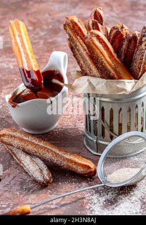 Bâtonnets de churros traditionnels à la cannelle et au chocolat. Banque D'Images