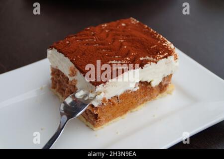 Un délicieux morceau de gâteau italien tiramisu sur une assiette carrée Banque D'Images