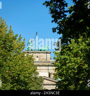 Quadriga à la porte de Brandebourg à Berlin vue par un écart entre les arbres de rue Banque D'Images