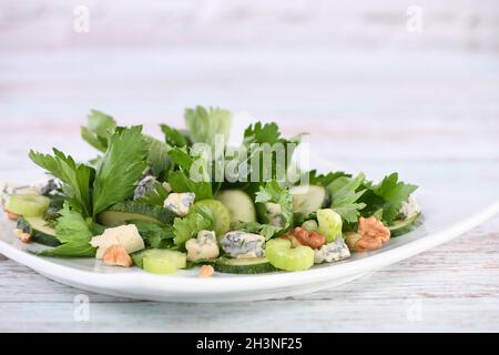 Salade de feuilles de céleri et de tiges avec tranches de concombre frais, fromage bleu, noix écrasées. Banque D'Images