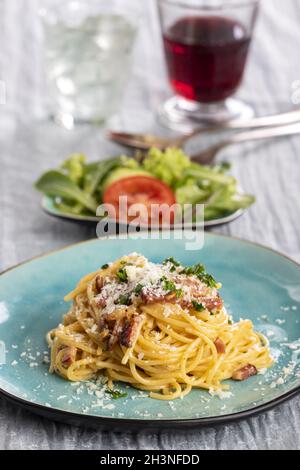 Spaghetti carbonara sur une assiette bleue Banque D'Images