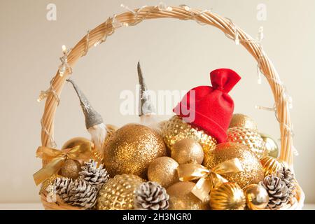 boules d'or à l'immense panier en osier avec chapeau de père noël rouge. Décoration pour sapin de Noël ou appartements Banque D'Images
