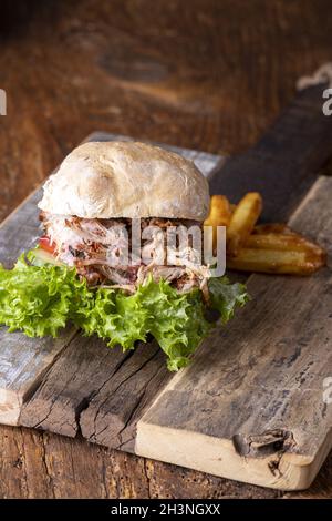 Porc tiré dans un petit pain avec des frites Banque D'Images