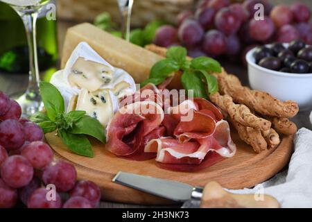 Antipasti. En-cas de jambon séché, camembert avec moule, parmesan avec graissini, olives Banque D'Images