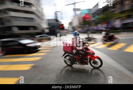 Kuala Lumpur, Malaisie.29 octobre 2021.Un pilote de livraison de nourriture passe devant une intersection près d'un quartier commerçant de Kuala Lumpur.(Photo de Wong Fok Loy/SOPA Images/Sipa USA) Credit: SIPA USA/Alay Live News Banque D'Images