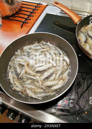 Faire frire le poisson avec de l'huile dans une poêle ronde.Des chefs pour les jeunes. Banque D'Images