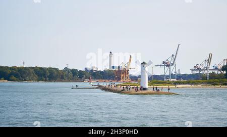 Touristes à la balise du moulin, le point de repère de la ville de Swinoujscie, en arrière-plan le port Banque D'Images