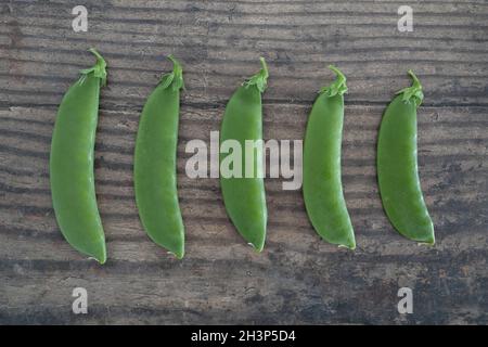 petits pois fraîchement cueillis, de gros à smal, sur une table à manger en bois, concept de simples ingrédients naturels sains Banque D'Images