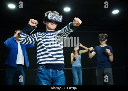 Emotive Tween boy jouant à vr jeu avec la famille Banque D'Images