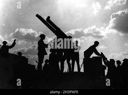 Les soldats silhouetés contre le ciel se préparent à tirer un fusil anti-avion pendant la bataille de Broodseinde pendant la campagne de Passchendaele. Banque D'Images