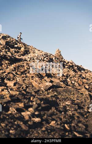 Un randonneur qui fait de la randonnée en bas d'une montagne. Banque D'Images