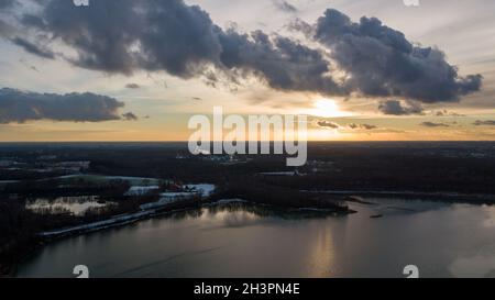Vue aérienne d'un magnifique et spectaculaire coucher de soleil sur un lac forestier reflété dans l'eau, paysage tir de drone Banque D'Images