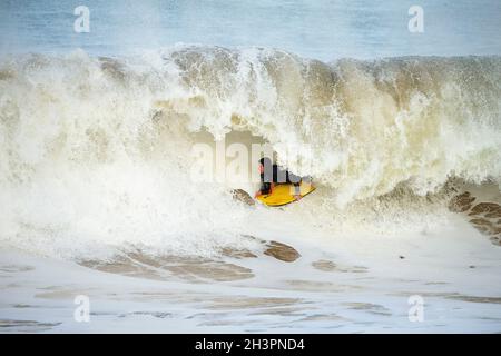 Surf à Portrush comme une grosse tempête de vague arrive au large de l'océan Atlantique et atteint la côte d'Antrim, en Irlande du Nord. Banque D'Images