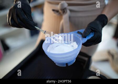 Jeune femme coiffant mourant des cheveux au salon de beauté.Professionnel cheveux racines coloration et mélange de couleur de peinture Banque D'Images