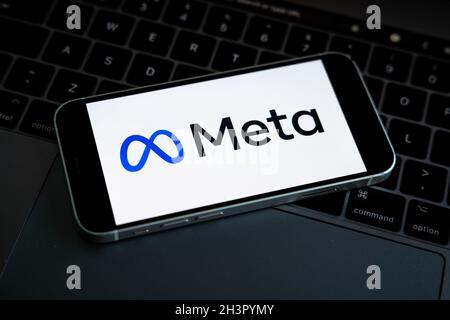 LE logo DE LA SOCIÉTÉ META est visible sur le smartphone en main avec le logo Facebook sur l'écran d'arrière-plan.Nouveau logotype de la société Facebook pour MÉTAVERSE. Banque D'Images