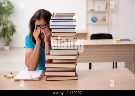 Jeune étudiant et beaucoup de livres dans le classe Banque D'Images