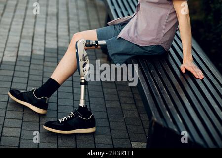 Jeune homme handicapé avec prothèse de pied assis à l'extérieur. Banque D'Images