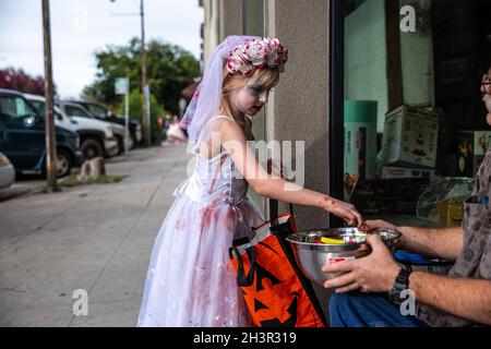 29 octobre 2020, Garberville, Californie, États-Unis :Une jeune fille habillée pour Halloween est vue obtenir des bonbons d'un voisin à sa porte d'entrée..à Garberville, un petit village dans le nord de la Californie, beaucoup de gens sont allés dans les rues habillées pour célébrer Halloween avec leurs enfants, qui sont allés porte à porte à la collecte de bonbons.(Credit image: © Antonio Cascio/SOPA Images via ZUMA Press Wire) Banque D'Images