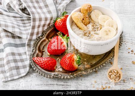 Porridge aux bananes, fraises et bleuets.Une alimentation saine Banque D'Images