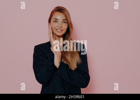 Portrait d'une femme d'affaires gaie à cheveux longs dans une veste classique noire Banque D'Images