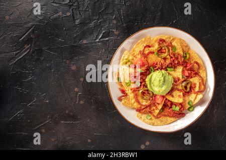 Nachos, chips de tortilla mexicaines, tiré d'en haut sur un fond sombre Banque D'Images