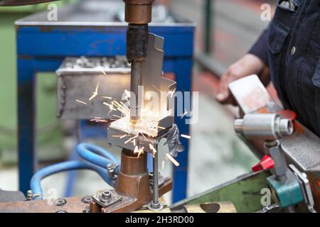 Gros plan d'un élément métallique soudé par points par un employé de l'usine. Concept de l'industrie. Banque D'Images