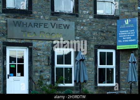 Vieux pittoresque salon de thé et café extérieur dans village rural pittoresque, à vendre ou louer panneau sur mur - Burnsall, Yorkshire Dales, Angleterre, Royaume-Uni. Banque D'Images