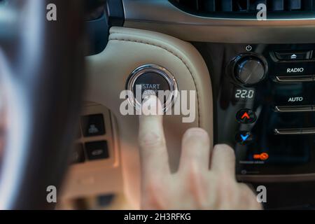 Le doigt de l'homme appuyant sur le bouton de démarrage.Utiliser le bouton-poussoir pour démarrer et arrêter le moteur.Le conducteur est prêt pour le voyage Banque D'Images