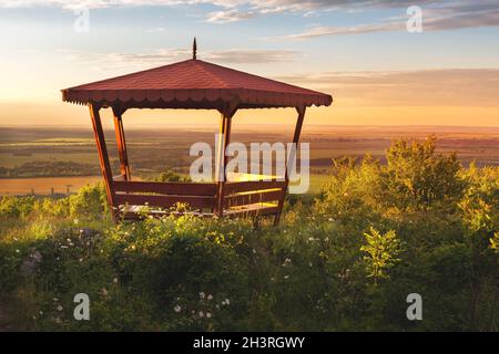 Belvédère en bois sur le paysage de coucher de soleil d'été Banque D'Images