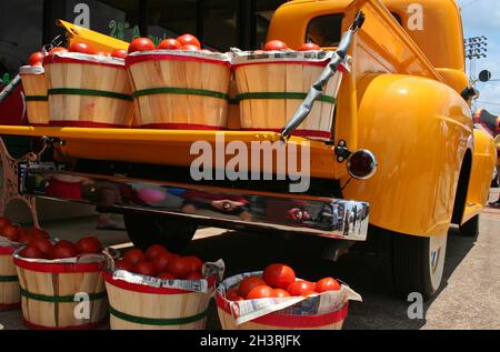 Camion jaune vintage avec paniers de tomates rouges Banque D'Images