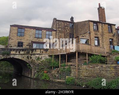 Une rangée de maisons anciennes à côté d'un pont traversant le canal rochdale dans le mytholmroyd West yorkshire Banque D'Images