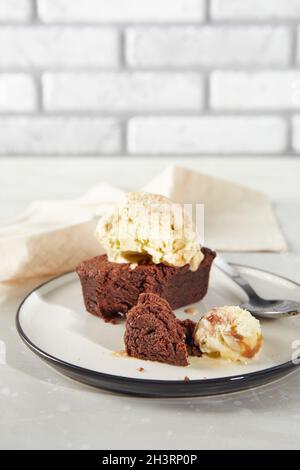 Dessert au chocolat Brownie avec une cuillère de crème glacée crémeuse aux noix sur l'assiette avec serviette Banque D'Images