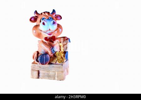 Jouet vache assis sur une chaise avec des pièces d'argent d'or Banque D'Images
