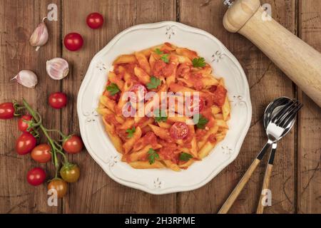 Photo en hauteur des pâtes de penne avec sauce tomate et ingrédients Banque D'Images