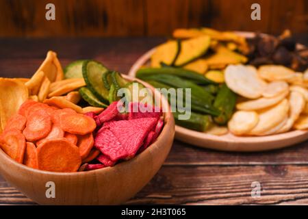 Croustilles de légumes maison sur plateau en bois alimentation biologique et nourriture végétalienne. Banque D'Images