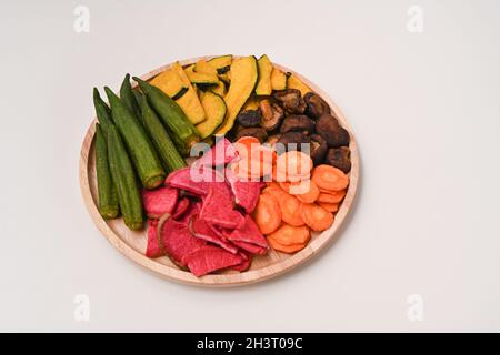 Croustilles de légumes séchées avec okra, carottes, citrouille, betteraves et champignons shiitake sur plateau en bois Banque D'Images