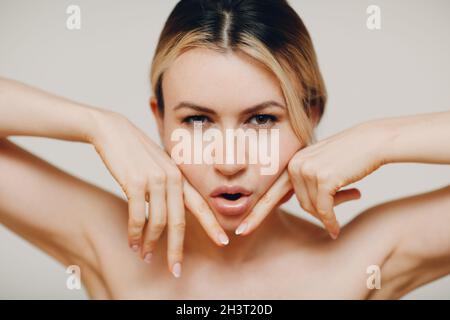 Femme faisant des massages de yoga du visage et des exercices rajeunissants facebuilding Banque D'Images