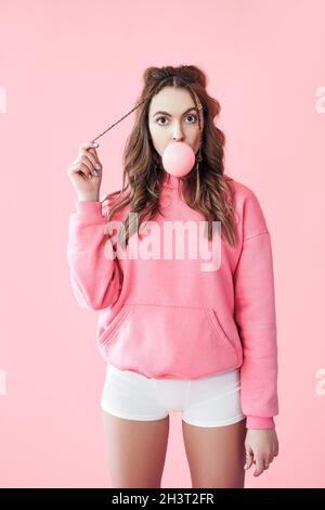 Jeune femme suprisée soufflant de la bulle de la gomme à mâcher Banque D'Images