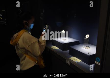 Hefei, Chine.29 octobre 2021.(211030) -- HEFEI, 30 octobre 2021 (Xinhua) -- Un citoyen voit un jadeware excavé sur le site reliques de Liangjiatan, au Musée Anhui à Hefei, province d'Anhui, en Chine orientale, le 30 octobre 2021.Beijing a dévoilé les médailles des Jeux olympiques et paralympiques d'hiver de 2022 le 26 octobre.Nommés 'Tongxin', signifiant 'ensemble comme un', les médailles comportent cinq anneaux concentriques, et leur conception arrière a été inspirée par le jadware 'Bi' découvert sur le site des reliques de Lingjiatan dans la province d'Anhui.Datant d'il y a environ 5,300 ans à 5,800 ans, Lingjiatan est connu pour la discothèque Banque D'Images
