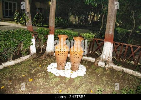 Paire de vases de boue dans LA DÉCORATION de jardin |ARBRES DANS LES LUMIÈRES DE JARDIN DANS LES VASES LUMIÈRES DANS LES PIERRES DE JARDIN DECORE Banque D'Images